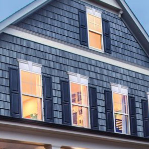 Close up of a home with blue siding and blue shutters on its windows