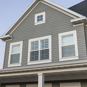 Close up of the side of a home with gray vinyl siding